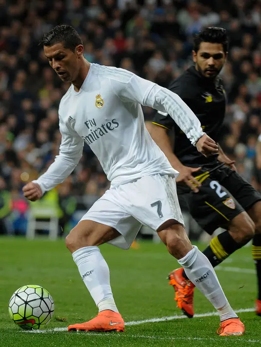Gelandang Real Madrid, Cristiano Ronaldo berusaha mengontrol bola dari kawalan bek Sevilla, Benoit Tremoulinas pada Liga Spanyol di Stadion Santiago Bernabeu (21/3). Real Madrid menang besar atas Sevilla dengan skor 4-0. (AFP/PEDRO ARMESTRE)