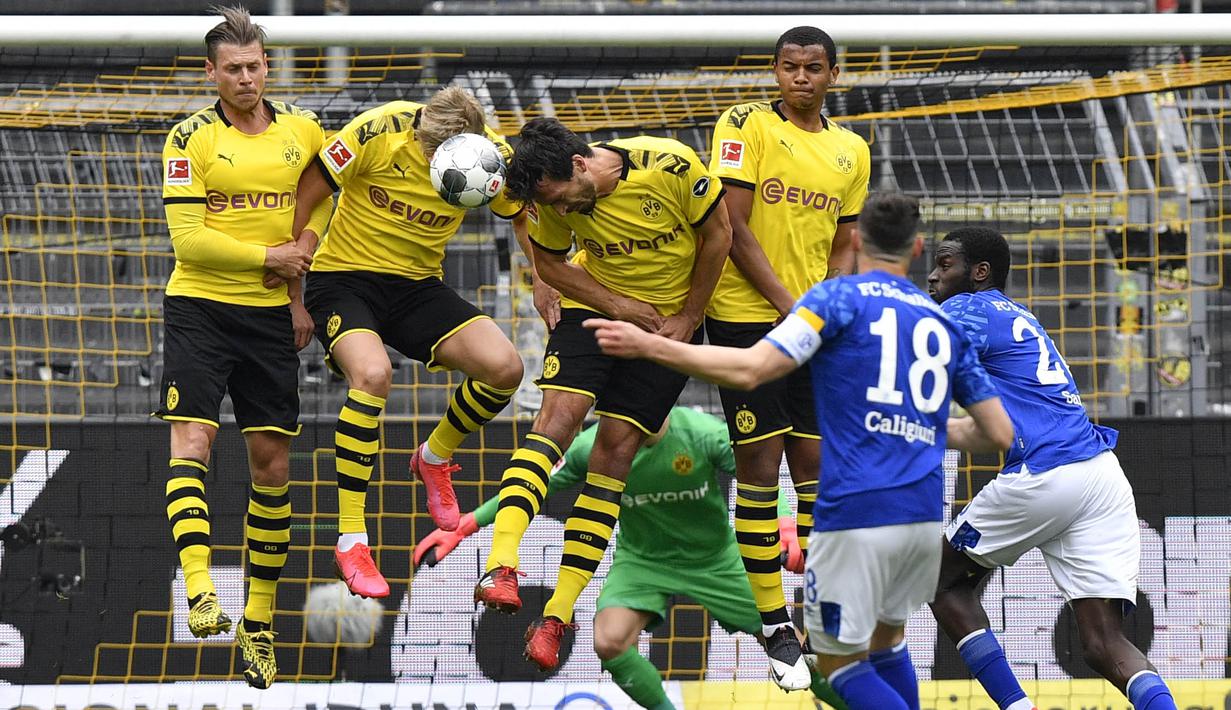 Para pemain Borussia Dortmund berusaha menghadang tendangan pemain Schalke 04, Daniel Caligiuri, pada laga Bundesliga di Stadion Signal Iduna Park, Sabtu (16/5/2020). Dortmund menang 4-0 atas Schalke 04. (AP/Martin Meissner)