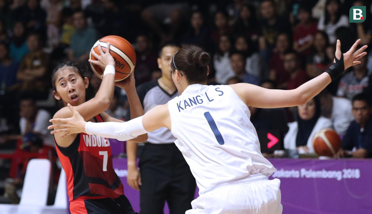 Pebasket putri Indonesia, Kadek Pratita Citta Dewi (kiri) mencoba menembus adangan pemain Korea, Kang Leeseui pada babak penyisihan Grup X Basket Putri Asian Games 2018 di Jakarta, Rabu (15/8). Indonesia kalah 40-108. (Liputan6.com/Helmi Fithriansyah)