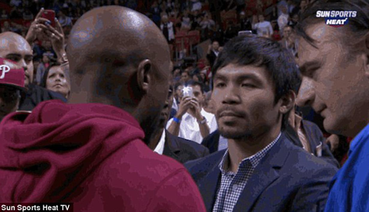 Floyd Mayweather Jr menghampiri Manny Pacquiao saat menyaksikan pertandingan NBA antara Miami Heat dan Milwaukee Bucks, AS, Rabu (28/1/2015). (Dailymail)