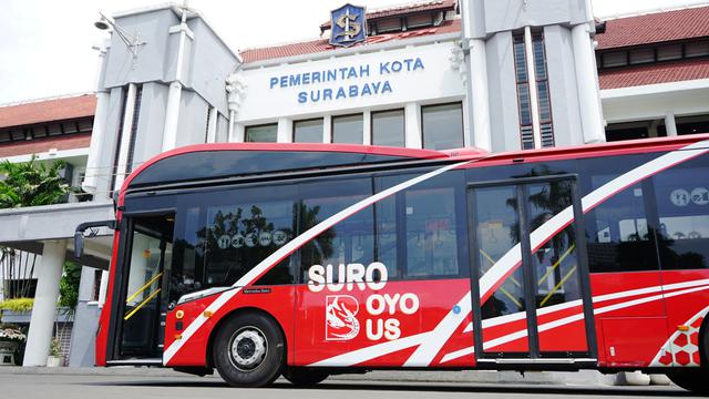suroboyo bus warna merah di depan kantor pemerintah kota surabaya