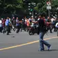Di tengah kepanikan pasca ledakan di Jalan Thamrin, Jakarta, seorang pria yang diperkirakan berusia antara 20-30 tahun, berpakaian kaos dan bertopi hitam serta membawa ransel merah, tiba-tiba mengeluarkan senjata, Kamis (14/1). (REUTERS/Veri Sanovri/Xin)