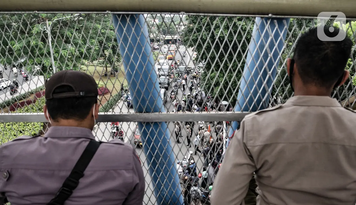 Polisi berjaga di depan Pengadilan Negeri Jakarta Timur saat jalannya sidang perdana Rizieq Shihab, Jakarta, Selasa (16/3/2021). Meski sidang digelar secara virtual, polisi tetap menjaga ketat PN Jakarta Timur guna mencegah kerumunan massa. (merdeka.com/Iqbal S. Nugroho)