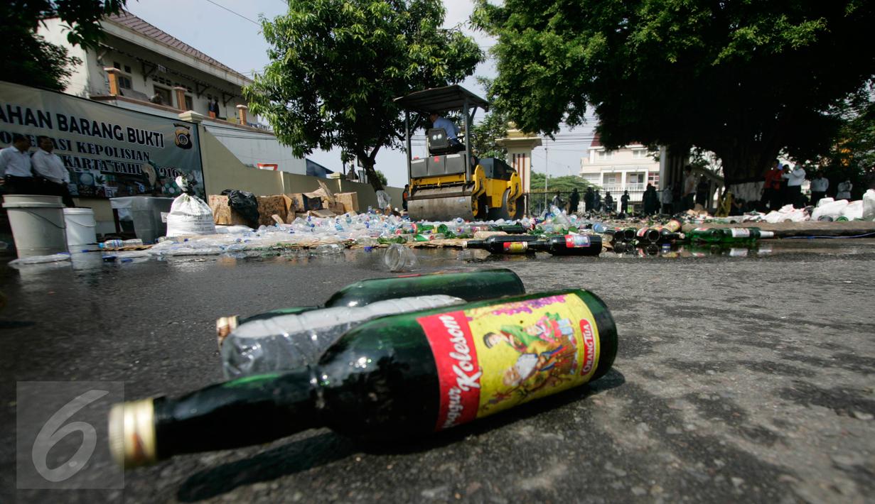 Alat berat melindas ribuan botol minuman keras (miras) saat pemusnahan barang bukti di halaman Mapolda DIY, Senin (6/6). Semua barang bukti yang dimusnahkan petugas merupakan hasil Operasi Pekat yang digelar sebelum Ramadan. (Liputan6.com/Boy Harjanto)