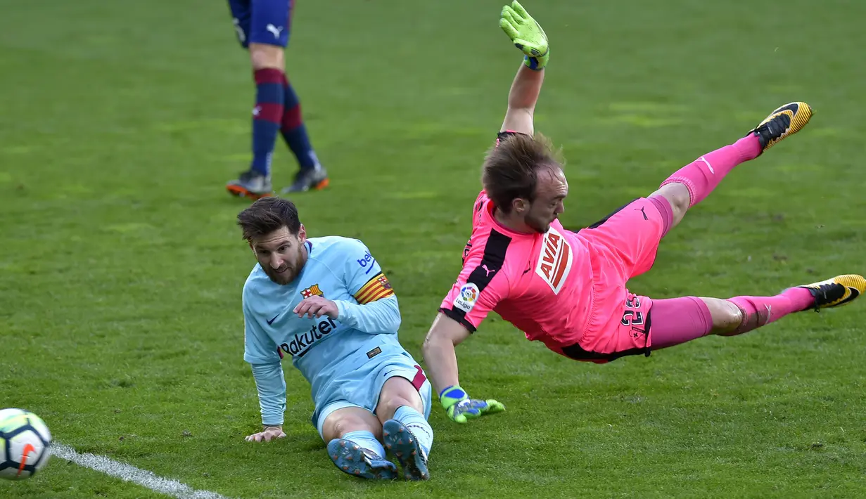 Lionel Messi (kiri) berusaha menjangkau bola dari adangan kiper Eibar, Marko Dmitrovic pada lanjutan La Liga Santander di Ipurua stadium,  Eibar, (17/2/2018). Barcelona menang 2-0. (AFP/Ander Gillenea)