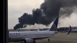 Kepulan Asap terlihat dari Pesawat American Airlines yang terbakar di Bandara O'Hare Chicago, AS (28/10). Sejumlah penumpang di dalam kabin telah dievakuasi ketika asap hitam mulai mengepul dari pesawat. (Courtesy of Robocast.com/Handout via REUTERS)