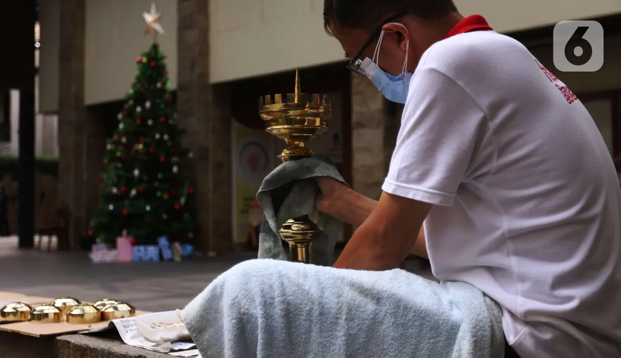 Seorang pria membersihkan peralatan jelang perayaan Natal di Gereja Katedral, Jakarta, Rabu (22/12/2021). Gereja Katedral Jakarta memperketat penerapan protokol kesehatan selama ibadah Natal 2021. (Liputan6.com/Angga Yuniar)