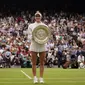 Marketa Vondrousova dari Republik Ceko merayakan dengan trofi setelah mengalahkan Ons Jabeur dari Tunisia untuk memenangkan final tunggal putri pada hari ketiga belas kejuaraan tenis Wimbledon di London, Sabtu, 15 Juli 2023. (AP Photo/Alberto Pezzali)