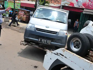 Petugas Dinas Perhubungan DKI Jakarta menderek mobil yang parkir di bahu jalan di kawasan Jatinegara, Jakarta, Senin (2/10). Razia parkir liar dilakukan untuk menertibkan kawasan tersebut. (Liputan6.com/Helmi Afandi)