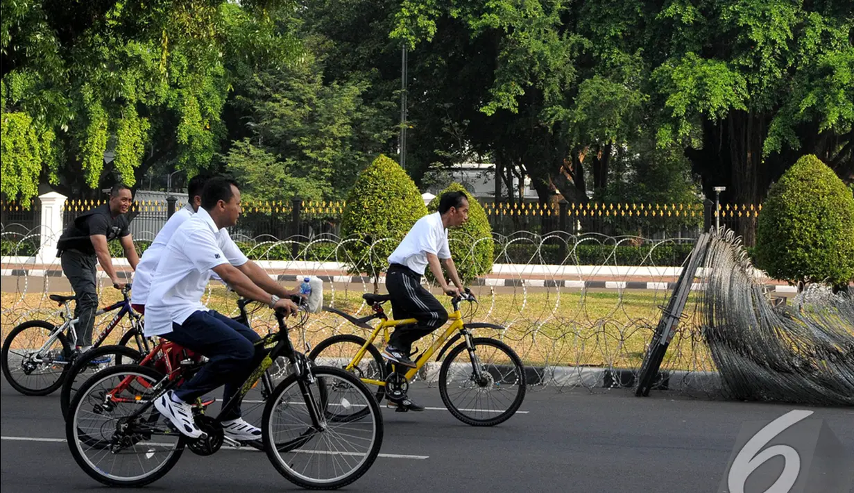 Presiden  Joko Widodo (Jokowi) memacu sepedanya menuju Istana Negara usai berkeliling di kawasan Car Free Day, Jakarta, Minggu (23/11/2014) (Liputan6.com/Herman zakharia)