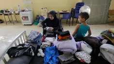 Seorang wanita Lebanon yang mengungsi melipat pakaian di dalam ruang kelas di sebuah sekolah yang menampung para pengungsi Lebanon, di kota Deir Ammar, Lebanon utara, pada 17 Oktober 2024. (Ibrahim Chalhoub/AFP)