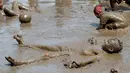 Nathan Jamerson, 10, bermain dalam kubangan lumpur saat Mud Day atau Hari Lumpur di Michigan, negara bagian AS, Selasa (9/7/2019). Para peserta perayaan yang menjadi tradisi setiap tahun ini merupakan anak-anak untuk agar mereka bersenang-senang selama liburan musim panas.  (AP/Carlos Osorio)