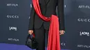 Kali ini, Halima Aden memilih tampilan elegan. Dengan set blazer dan celana panjang hitam, Halima memilih detail unik di bagian blazernya, yaitu selipan selendang merah panjang. [Foto: Instagram/halima]
