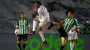Bek Real Madrid, Eder Militao (tengah) berebut bola dengan striker Real Betis, Loren Moron dalam laga lanjutan Liga Spanyol 2020/2021 pekan ke-33 di Alfredo Di Stefano Stadium, Madrid, Sabtu (24/4/2021). Real Madrid bermain imbang 0-0 dengan Real Betis. (AFP/Gabriel Bouys)