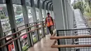 Pekerja melintas di jembatan penyeberangan orang (JPO) Bundaran Senayan, Jakarta, Senin (21/1). (Liputan6.com/Faizal Fanani)