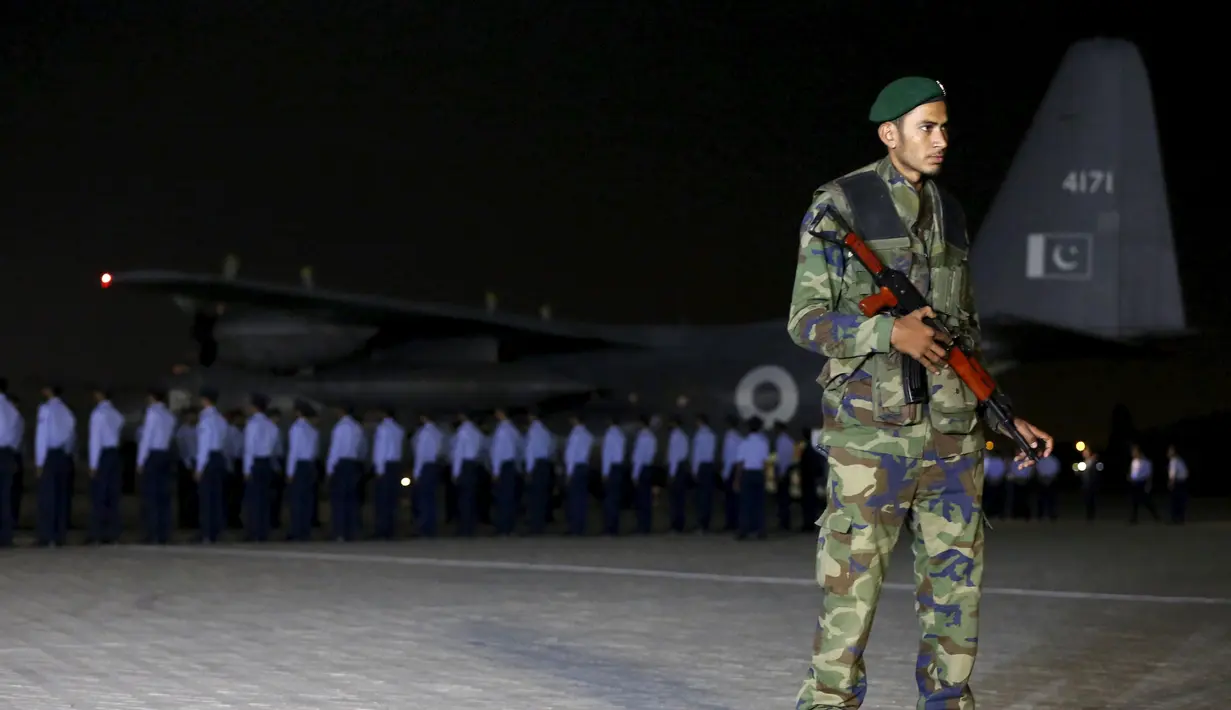 Petugas berjaga saat upacara penghormatan untuk pilot jet tempur Pakistan, Marium Mukhtiar (22) di pangkalan AU di Karachi, Selasa (24/11). Marium tewas setelah pesawatnya mengalami kecelakaan di Provinsi Punjab. (REUTERS/Akhtar Soomro)