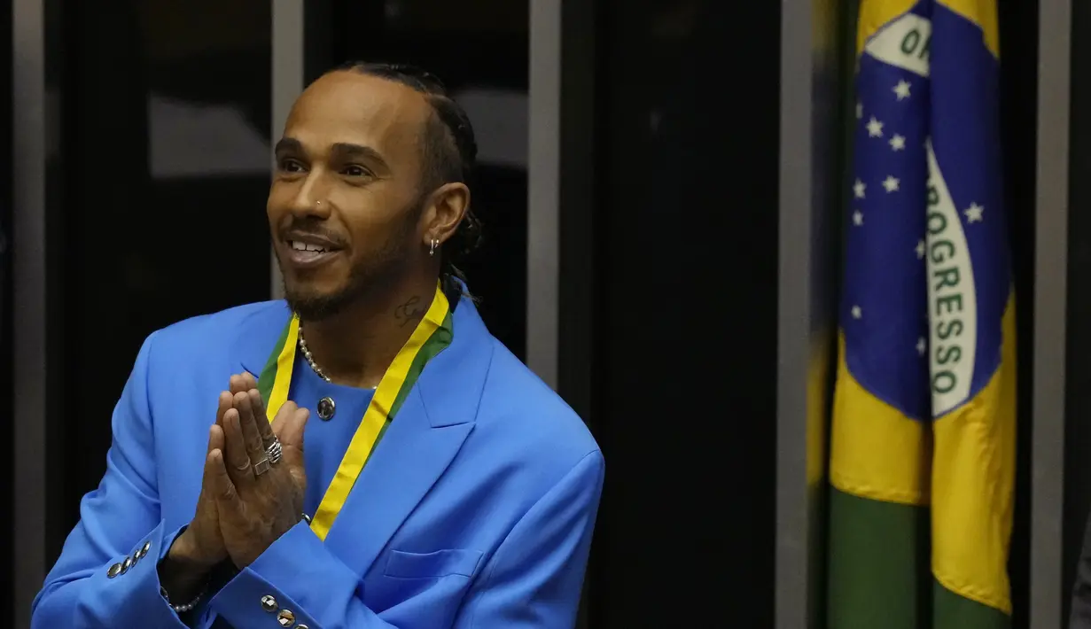 Pembalap Formula 1 Mercedes asal Inggris, Lewis Hamilton menyapa kerumunan di Chamber of Deputies saat upacara menerima gelar Warga Kehormatan Brasil di Brasilia, Brasil, Senin (7/11/2022). Lewis Hamilton menerima sertifikat warga negara kehormatan Brazil yang akan menjadi tuan rumah grand prix pada akhir minggu ini. (AP Photo/Eraldo Peres)