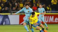 Bintang Barcelona, Lionel Messi, berebut bola dengan pemain Las Palmas, Ximo Navarro, dalam laga yang berkesudahan 1-1 di Estadio Gran Canaria, Kamis (1/3/2018).  (AP Photo/Lucas de Leon)