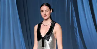 Aktris Renate Reinsve tampil memesona dalam gaun tanpa lengan berwarna hitam dan perak dengan detail bordir yang rumit serta potongan leher deep polo neckline yang menambah kesan anggun dan modern. Ia memadukan tampilannya dengan sepatu hak satin hitam serta perhiasan dari koleksi Le Damier de Louis Vuitton Fine Jewelry, termasuk kalung, cincin, dan gelang dari emas putih bertabur berlian. [Dok/Louis Vuitton].