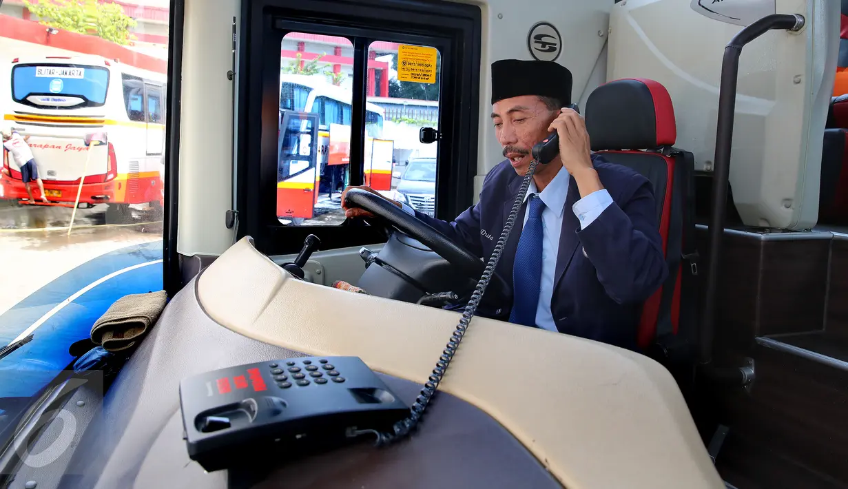 Supir Bus Harapan Jaya sedang melakukan panggilan lewat telepon di dalam bus jurusan Jakarta-Blitar di Pool Ciputat, Tangerang Selatan. Bus dengan chassis Swedia ini hadir dengan fitur unggulan. (Liputan6.com/Fery Pradolo)