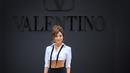 Ashley Park tampil memesona dengan croptop shirt berwarna putih dengan silk long shirt. Dipadukan dengan untied tie dan tas dari Valentino Garavani. (Valentino)