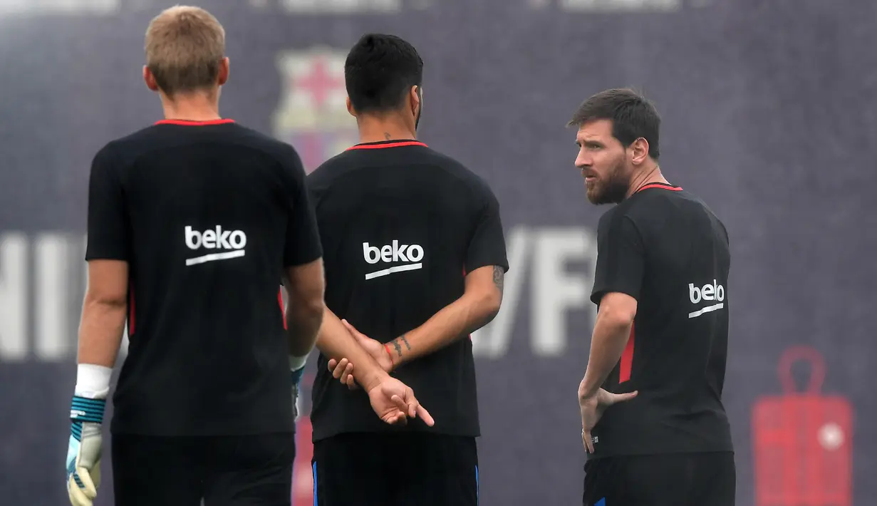 Pemain Barcelona, Lionel Messi (kanan) berbincang dengan rekannya Luis Suarez saat sesi latihan di Sports Center FC Barcelona Joan Gamper, Sant Joan Despi (15/8/2017). Barcelona akan melawan Madrid pada leg kedua Piala Super Spanyol. (AFP/Lluis Gene)