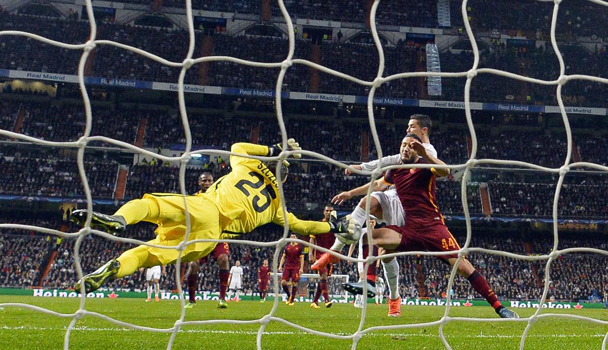 Cristiano Ronaldo (tengah) mencoba mencetak gol saat diahadang kiper AS Roma, Wojciech Szczesny dan Konstas Manolas pada leg kedua babak 16 besar  Liga Champion di Stadion Santiago Bernabeu, Madrid, Rabu (9/3/2016) dini hari WIB. (AFP/Gerard Julien)