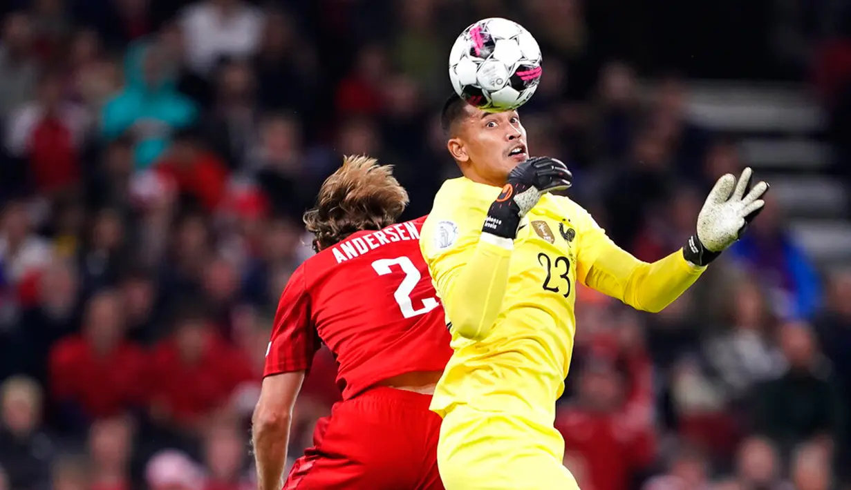 Pemain Denmark Joachim Andersen (kiri) berebut bola udara dengan penjaga gawang Prancis Alphonse Areola pada pertandingan sepak bola UEFA Nations League di Parken Stadium, Kopenhagen, Denmark, 25 September 2022. Denmark mengalahkan Prancis dengan skor 2-0. (Liselotte Sabroe/Ritzau Scanpix via AP)