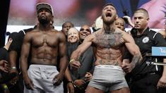 Petarung MMA, Conor McGregor dan petinju Floyd Mayweather Jr saat sesi timbang berat badan di Las Vegas, Jumat (25/8/2017). Keduanya akan bertarung pada Minggu (27/6/2017) di T-Mobile Arena, Las Vegas, Amerika Serikat. (AP/John Locher)