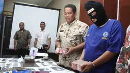 Kepala BNN, Komjen Pol Anang Iskandar menunjukkan tersangka Fit (37) beserta barang bukti kasus pencucian uang hasil bisnis narkotika ke dalam bisnis jual beli kendaraan roda empat di Gedung BNN, Jakarta, Jumat (21/8/2015). (Liputan6.com/Gempur M Surya)