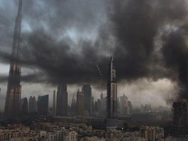 Asap mengepul di lokasi konstruksi sebelah Dubai Mall, Uni Emirat Arab, Minggu (2/4). Kebakaran terjadi sekitar pukul 06.30 pagi waktu setempat. (AP Photo/ Anthea Ayache)