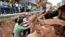 Sejumlah petugas berusaha mengangkat fosil telur Dinosaurus , Heyuan, Tiongkok, Kamis (23/4/2015). Fosil ditemukan secara tidak sengaja saat perbaikan jalan untuk pemasangan pipa(AFP Photo/China Out)