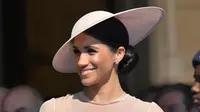 Duchess of Sussex, Meghan Markle menghadiri pesta kebun Istana Buckingham di London, Selasa (22/5). Meghan Markle mulai menunjukkan statement look dirinya dan menampilkan fashion ala kerajaan Inggris. (Dominic Lipinski/Pool Photo via AP)