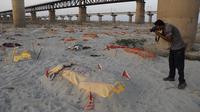 Jenazah korban terduga Covid-19 terlihat di kuburan dangkal di tepi sungai Gangga di Prayagraj, 15 Mei 2021. Polisi menjangkau penduduk desa di India utara untuk menyelidiki penemuan jasad di tepi Sungai Gangga yang memicu spekulasi mereka adalah jenazah korban COVID-19 (AP Photo/Rajesh Kumar Singh