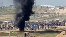 Suasana protes warga Palestina dari kibbutz Israel selatan dari Nahal Oz di perbatasan garis Gaza (6/4). Ribuan ban telah disiapkan untuk dibakar di perbatasan Gaza, tujuannya mengaburkan pandangan penembak jitu tentara Israel. (AFP Photo/Jack Guez)