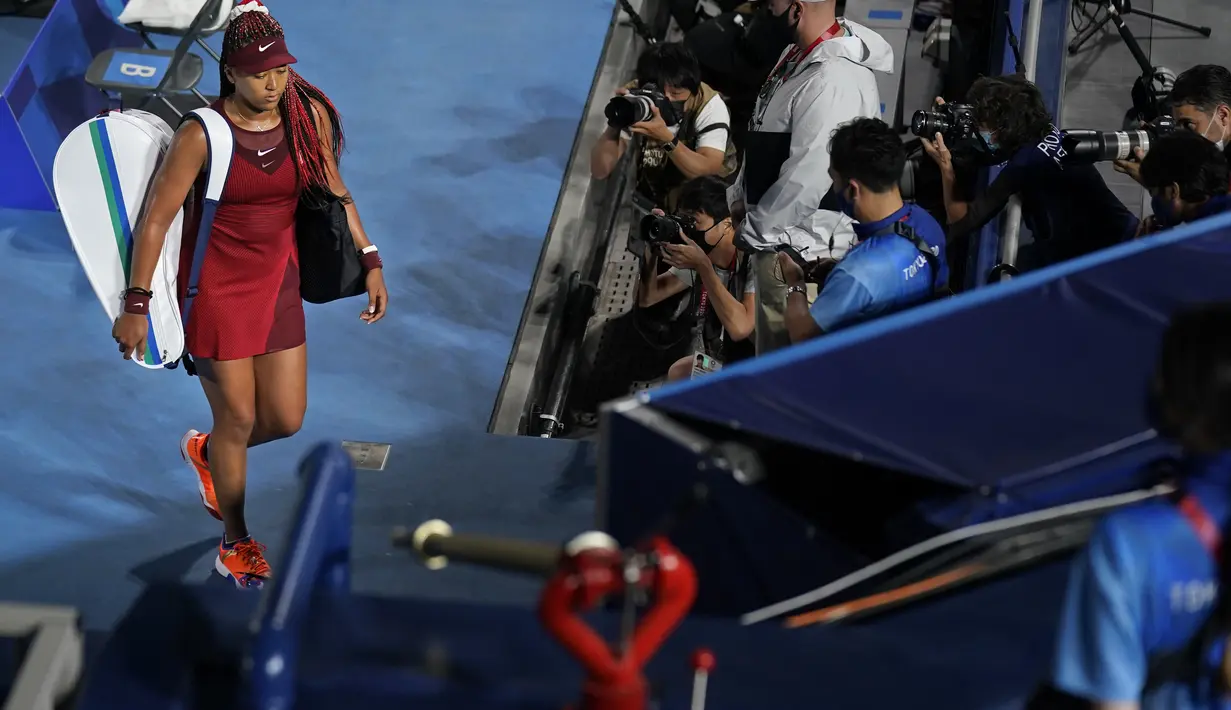 Petenis Jepang Naomi Osaka meninggalkan lapangan setelah dikalahkan Marketa Vondrousova dari Republik Ceko dalam pertandingan tenis putaran ketiga tunggal putri Olimpiade Tokyo 2020 di Ariake Tennis Park di Tokyo (27/7/2021). Naomi kalah dari Marketa Vondrousova 6-1, 6-4. (AP Photo/Seth Wenig)