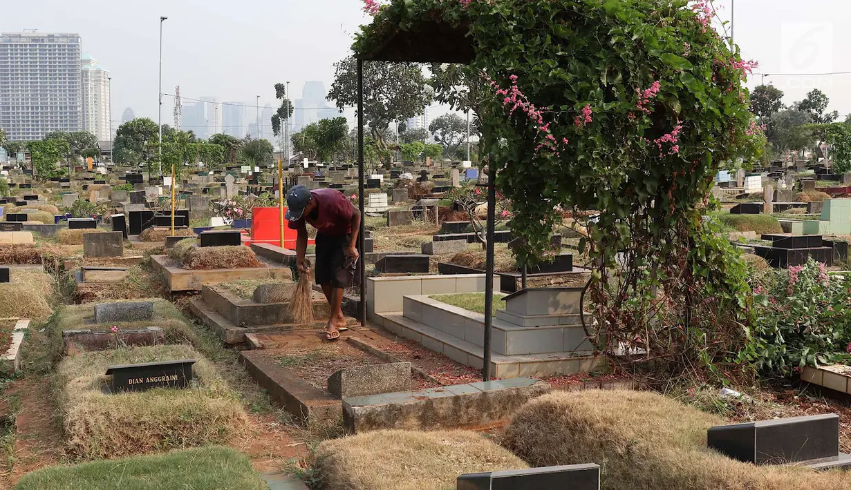 Pekerja membersihkan makam di TPU Karet Bivak, Jakarta, Kamis (26/7). Wagub DKI Jakarta Sandiaga Uno menyatakan akan mencari dan memerbanyak area TPU di Ibukota yang akan dimasukkan dalam anggaran Pemprov DKI tahun depan. (Liputan6.com/Immanuel Antonius)