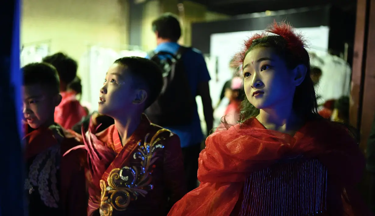 Model cilik menunggu di belakang panggung sebelum menampilkan kreasi dari koleksi Jinshangyuyi karya desainer Wang Cong selama China Fashion Week di Beijing pada Kamis (9/9/2021). Gelaran pekan mode tersebut tetap digelar di tengah pandemi corona covid-19. (Giok GAO / AFP)