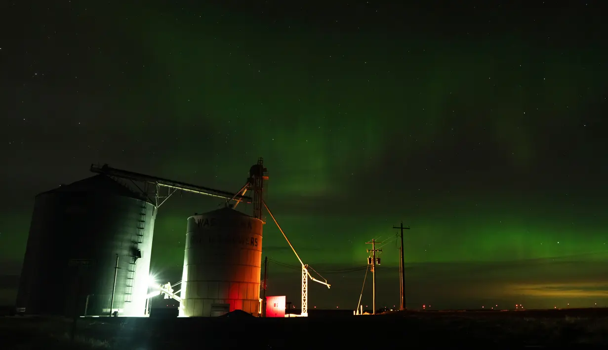 Sebuah aurora borealis, juga dikenal sebagai cahaya utara, terlihat pada langit malam di samping elevator biji-bijian dekat Washtucna, Washington, Amerika Serikat, 26 Februari 2023. Pengamat langit di Amerika Serikat melaporkan pita berwarna-warni menari dari Alaska, Seattle, Michigan, Upstate New York dan sejauh selatan Ohio. (AP Photo/Ted S. Warren)