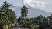Aktivitas warga saat Gunung Merapi memuntahkan material vulkanik dari kawahnya di Sleman, Yogyakarta (7/1/2021). Kondisi cuaca disekitar gunung terpantau cerah hingga hujan, angin lemah hingga sedang ke arah timur, barat daya dan barat. (AP Photo/Slamet Riyadi)