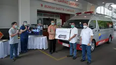 Chief Astra Financial Adi Sepiarso secara simbolis menyerahkan satu unit mobil Ambulance Gawat Darurat kepada Dirut RS St Carolus, Rudyan Kopot (tengah) di Rumah Sakit St Carolus, Jakarta, Rabu (8/4/2020). Selian mobil ambulance juga diserahkan peralatan medis. (Liputan6.com/HO/Eko)
