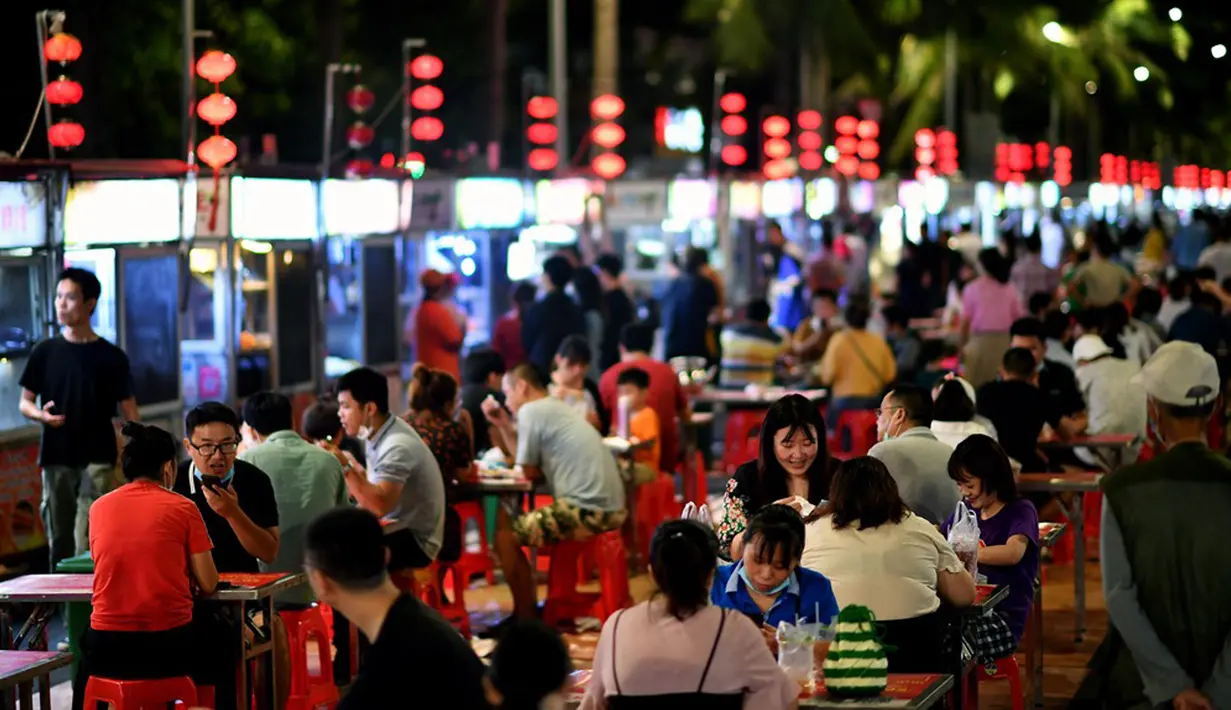 Warga menikmati makanan ringan di sebuah pasar malam di Haikou, ibu kota Provinsi Hainan, China selatan (26/3/2020). Kehidupan masyarakat di provinsi tersebut secara bertahap mulai kembali normal. (Xinhua/Guo Cheng)