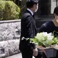 Seorang perwakilan toko bunga membawa bunga belasungkawa di kediaman mantan Perdana Menteri Jepang Shinzo Abe di Tokyo. (Foto AP/Eugene Hoshiko)