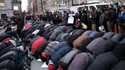 Ratusan pengunjuk rasa melakukan salat berjamaah di New York, AS (2/2). Unjuk rasa dilakukan karena adanya perintah eksekutif Donald Trump yang melarang imigran dan pengungsi dari tujuh negara mayoritas muslim. (Spencer Platt / Getty Images / AFP)