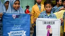 Dua orang pelajar menunjukkan spanduk saat menggelar demonstrasi menolak perayaan Hari Valentine di Surabaya, Jawa Timur, Kamis (14/2). Pelajar menilai Valentine sebagai pengaruh budaya asing. (Juni Kriswanto/AFP)