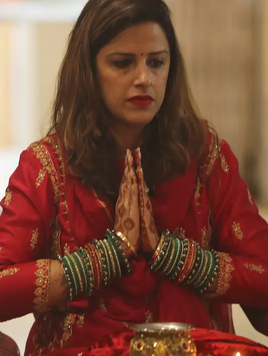 Seorang wanita Hindu berdoa sebelum berbuka puasa sepanjang hari selama festival 'Karwa Chauth', di Jammu, India, Rabu (4/11/2020). Wanita Hindu yang menikah berpuasa dan berdoa ke bulan untuk kesejahteraan, kemakmuran, dan umur panjang suami mereka di festival ini. (AP Photo/Channi Anand)