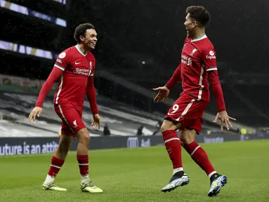 Bek Liverpool, Trent Alexander-Arnold (kiri) berselebrasi dengan rekannya Roberto Firmino usai mencetak gol ke gawang Tottenham Hotspur pada pertandingan lanjutan Liga Inggris di Stadion Tottenham Hotspur, London, Jumat (29/1/2021). Liverpool menang atas Tottenham 3-1. (Catherine Ivill/Pool via AP)