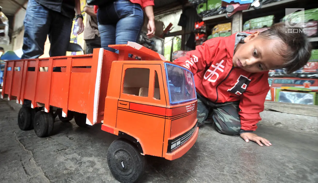 Seorang anak melihat mainan kayu di kawasan Kalibata, Jakarta, Rabu (17/10). Sukma merupakan satu dari segelintir pedagang mainan lokal di Ibu Kota yang masih bertahan dari ekspansi pasar impor. (Merdeka.com/Iqbal S. Nugroho)