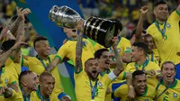 Pemain belakang timnas Brasil, Dani Alves mengangkat trofi Copa America 2019 saat berselebrasi bersama rekan setimnya setelah mengalahkan Peru pada partai final di Maracana Stadium, Rio de Janeiro, Senin (8/7/2019) dini hari WIB. Brasil menundukkan Peru dengan skor 3-1. (Juan MABROMATA/AFP)