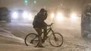 Pesepeda menunggu untuk menyeberangi jalan di tengah badai musim dingin di pusat kota Chicago, AS, 29 Desember 2020. Para komuter pagi di Chicago menghadapi jalanan yang licin dan lalu lintas yang lambat pada Rabu (30/12) saat badai musim dingin besar pertama melanda kota itu. (Xinhua/Joel Lerner)